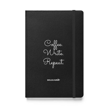 Black hardcover writing journal with "Coffee. Write. Repeat." in white and Boldly Write Logo.